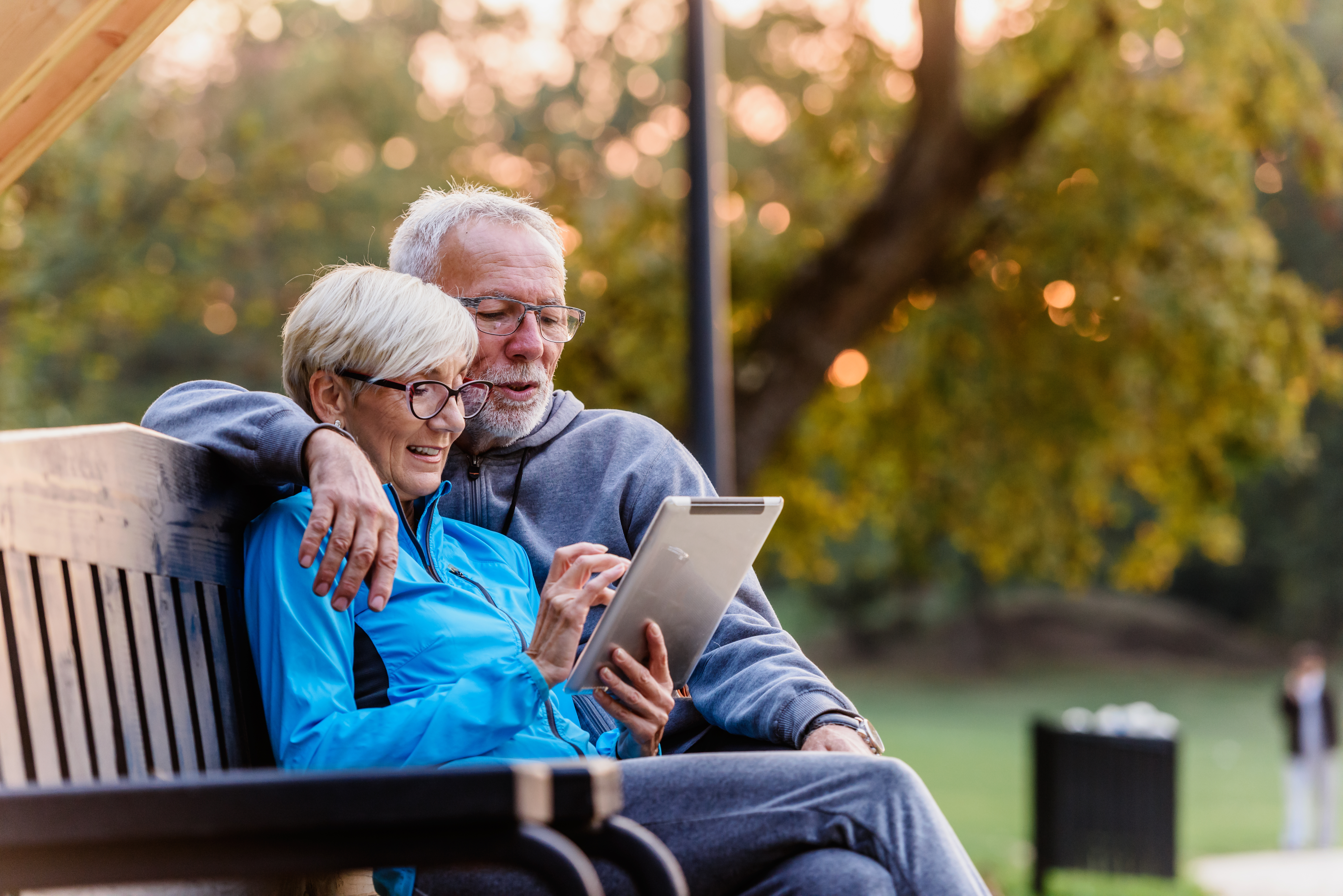 Happy older woman smiling while using a tablet computer